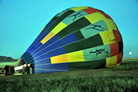 Preparing the balloon for take-off prior to sunrise. Note the moon.